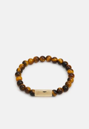 Ronde armband van gepolijste tijgeroog kralen in bruin en gouden tinten, met een gestructureerde goudkleurige sluiting met gravure.
