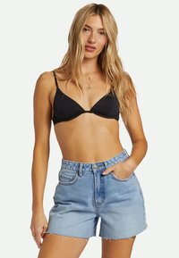 Zwart driehoekig bikini-topje gecombineerd met hoog-getailleerde, lichtblauwe denim shorts met rafelige zomen en een klassieke vijf-pocket stijl.