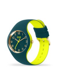 Färgglad klocka med ett grönt silikonarmband och en ljusgul insida, med en rund urtavla i guldfärg med tydliga siffror och visare.