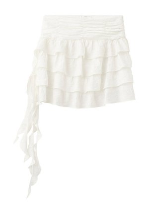 Mini-jupe blanche à volants superposés avec taille froncée et long volant asymétrique tombant du côté gauche.