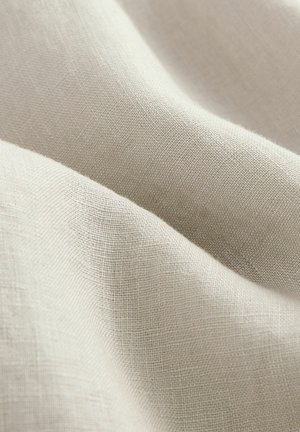Lichtbeige linnen stof met een gestructureerd oppervlak, vertonend zachte, vloeiende draperieën en een fijn weefpatroon.