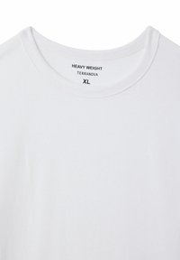 Biała, ciężka koszulka z okrągłym dekoltem, z nadrukowaną etykietą "HEAVY WEIGHT TERRANOVA XL" na wewnętrznej stronie kołnierza.