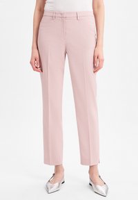 Lichtroze rechte broek met een gestructureerde stof, zijzakken en een gladde tailleband, gecombineerd met zilveren puntige schoenen.