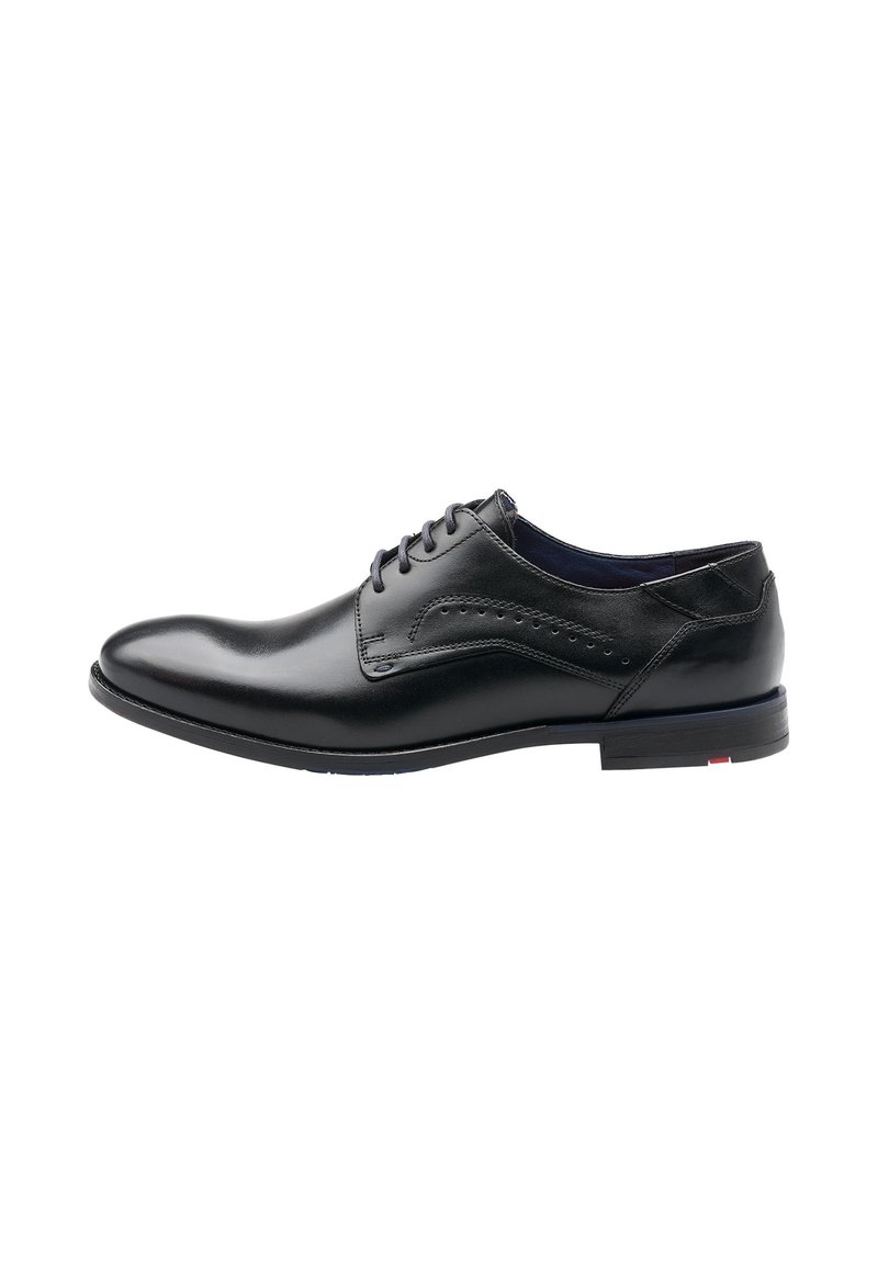 Chaussure habillée en cuir noir avec un orteil arrondi, un système de laçage, des perforations décoratives et un petit talon empilé.