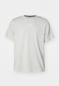 Světle šedé tričko s krátkým rukávem vyrobené z měkké tkaniny, s bílým logem Jordan umístěným na hrudi a kulatým výstřihem.