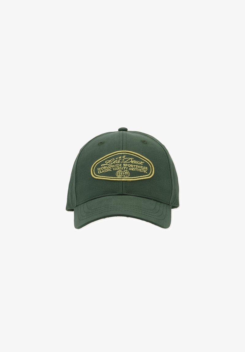 Casquette de baseball vert foncé avec visière incurvée et écusson brodé jaune portant l'inscription "Worldwide Sportswear Classic Varsity Aesthetic" à l'avant.