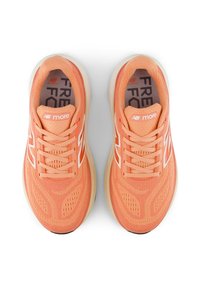 Lichte perzikkleurige hardloopschoenen met een ademende mesh bovenkant, dikke demping en witte accenten. Beschikt over veters en een geprofileerde zool.