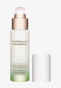 Siero potenziante barriera in una bottiglia trasparente satinata, con una sfumatura dal verde al trasparente. Cappuccio pompante metallico dorato, tappo avvitato bianco. Testo sulla bottiglia.