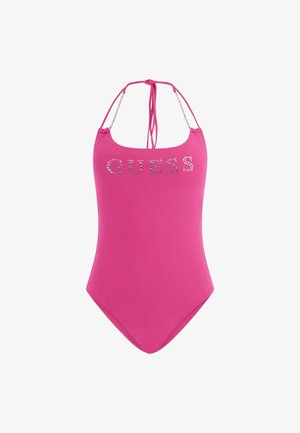Roza enodelna kopalka z nastavljivimi trakovi na vratu, ki ima bleščeč logotip "GUESS" spredaj in gladko, elastično teksturo.