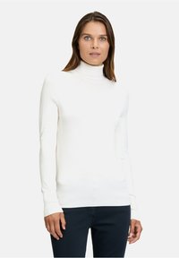 Weißer Rollkragenpullover aus geripptem Stoff, taillierte Passform, lange Ärmel und eine glatte Textur, kombiniert mit dunkler Hose.