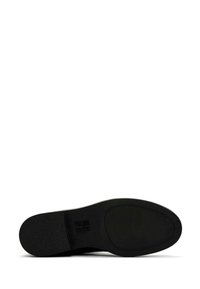 Black shoe sole with textured surface, rounded shape, and smooth edges. Features a slight heel and embossed logo detail.