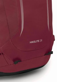 Close-up van een kastanjebruine wandelrugzak met gaas zijpanelen, reflecterende strepen en het label "HIKELITE 28" op de onderste voorkant.