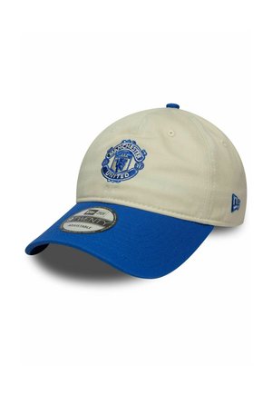 Manchester United baseball cap with beige crown and blue brim, adjustable strap, and embroidered team logo on front.