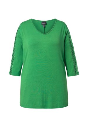 Maglietta verde a scollo a V con maniche a tre quarti, caratterizzata da decorazioni di paillettes nere lungo i lati esterni di entrambe le maniche.