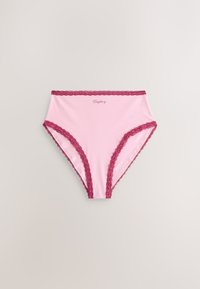 Pink dametrusse med høj talje med mørkerød blondekant og "Tuesday" skrevet med små bogstaver midt på fronten af linningen.