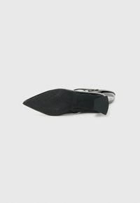 Chaussure à talon haut noire avec un bout pointu, dotée d'une semelle texturée et d'un talon mince et angulaire. Le design comprend un accent de boucle décorative.