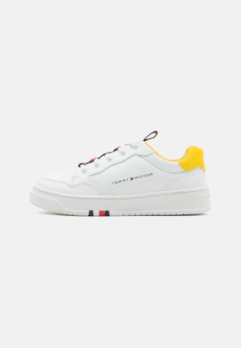 Sneaker bianco con accento giallo sul tallone, materiale in pelle, punta rotonda e dettagli a contrasto rossi e blu scuro sulla suola. Marchio sul lato.