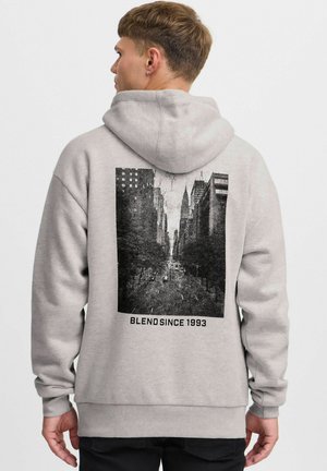 Hoodie gris clair avec un imprimé graphique noir représentant une scène de rue au dos, accompagné du texte "BLEND SINCE 1993" sous l'image.