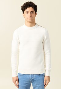 Weißer strukturierter Strickpullover mit rundem Ausschnitt, horizontalen Rippmustern und vier dekorativen Knöpfen an der linken Schulter.