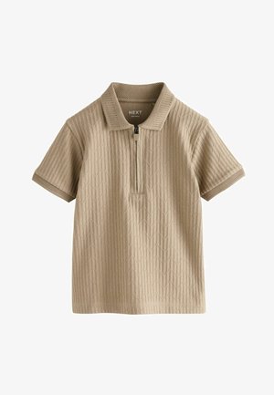 Bež kratka polo majica s patentnim zatvaračem na ovratniku, teksturiranim geometrijskim uzorkom i mrežastim detaljima na rukavima. Izrađena od lagane tkanine.