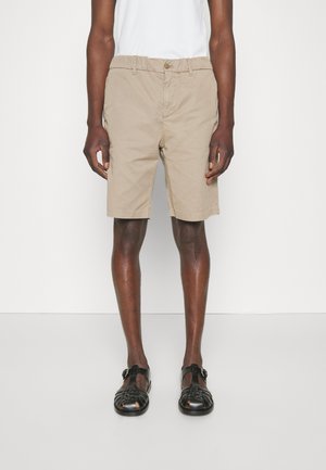 Καρό σορτς από βαμβάκι, με άνετη εφαρμογή, ελαστική μέση και πλαϊνές τσέπες. Φοριούνται με μαύρες υφαντές σαγιονάρες.