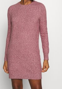 Abito a maglia a maniche lunghe di colore rosa melange, con scollatura rotonda e silhouette aderente, realizzato in un morbido tessuto testurizzato.
