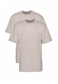 Beige cotton t-shirts with short sleeves and a crew neckline, featuring a white signature logo printed on the chest. Pack of two.