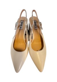 Scarpe slingback beige con punta a punta e finitura lucida, dotate di una fibbia decorativa e un design con tallone aperto. Realizzate in pelle.