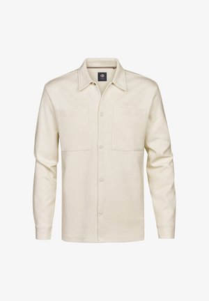 Camisa de manga larga color beige claro, fabricada con tela suave, que presenta un cuello puntiagudo, dos bolsillos en el pecho y cierre con botones al frente.