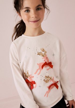 Felpa bianca con renna rosa decorata con paillettes dorate e fiocchi rossi. Tessuto morbido, scollo rotondo e vestibilità morbida.