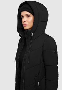 Chaqueta de plumas negra con un alto cuello y capucha, con textura de acolchado, cierre de cremallera y paneles laterales elásticos para mayor comodidad.