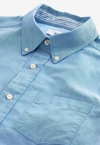 Hemd in Hellblau aus weichem Baumwollstoff, mit einer einzelnen Brusttasche und einem gestreiften Innenkragen. Klassisches Design mit Knopfverschluss.