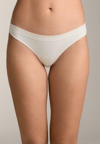 Baumwollmischung String-Unterwäsche in Hellbeige mit glatter Textur, ausgestattet mit einem breiten Bund und minimalistischen Nähten.