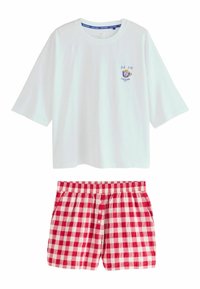 Hvid top med korte ærmer med teksten "But first, coffee" og kopbroderi, kombineret med elastiske shorts med rødt og hvidt tern, der har knapper i taljen.