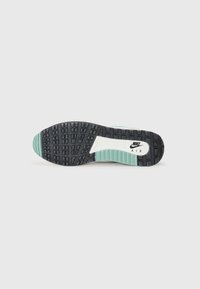 Czarna gumowa podeszwa buta z teksturowanym wzorem antypoślizgowym, z białym logo Nike Air na środku oraz miętowymi akcentami na brzegach.