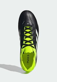 Zwarte voetbalschoen met een glanzende leren bovenkant, contrasterende felgele kraag en interieur, zwarte veters en witte accenten aan de zijkanten.