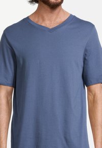 V-hals, kortafshirt in effen blauw, gemaakt van zachte, lichte stof. Kenmerkt zich door een ontspannen pasvorm met een soepele textuur.