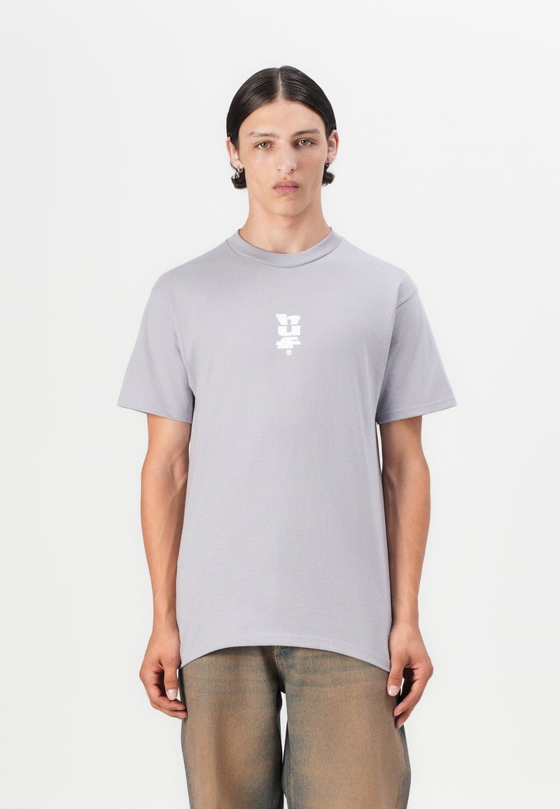 Lys grå kortærmet t-shirt med rund hals; har et hvidt grafisk logo på brystet; lavet af blødt bomuldsstof.