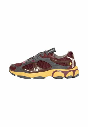Zapatilla deportiva granate, gris y amarilla con paneles de malla, cordones y una suela gruesa acolchada mostrada de lado.