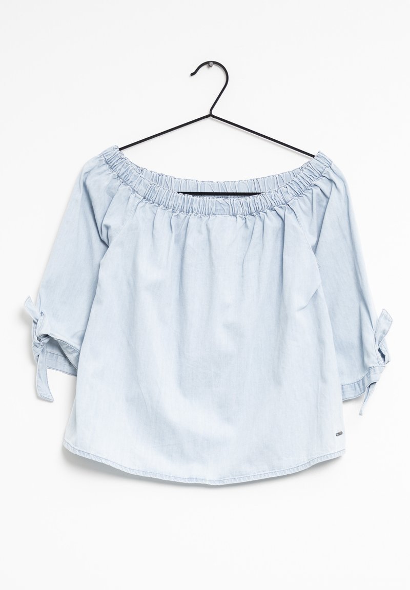 Blouse bleu clair à épaules dénudées avec encolure froncée, manches trois-quarts, et accent noué sur les manches. Tissu en coton lisse.