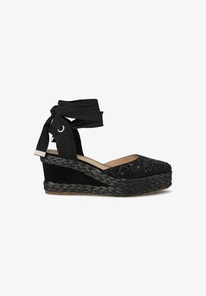 Schwarze Keilsandalen mit einem strukturierten, verzierten Obermaterial, sanften Wildlederelementen und einer geflochtenen Jutemittelsohle. Verfügt über verstellbare Stoffriemen.