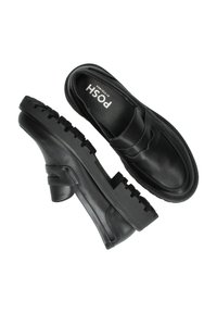 Zwarte leren schoenen met een ronde neus, platte rubberen zool en een lage hak. Heeft een decoratieve band over de wreef.