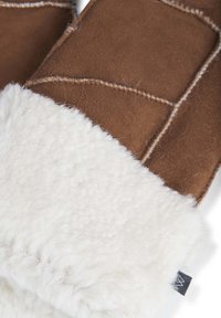 Mittens in suede marrone con un morbido polsino in shearling bianco. I dettagli cuciti aggiungono texture, migliorando calore e comfort.