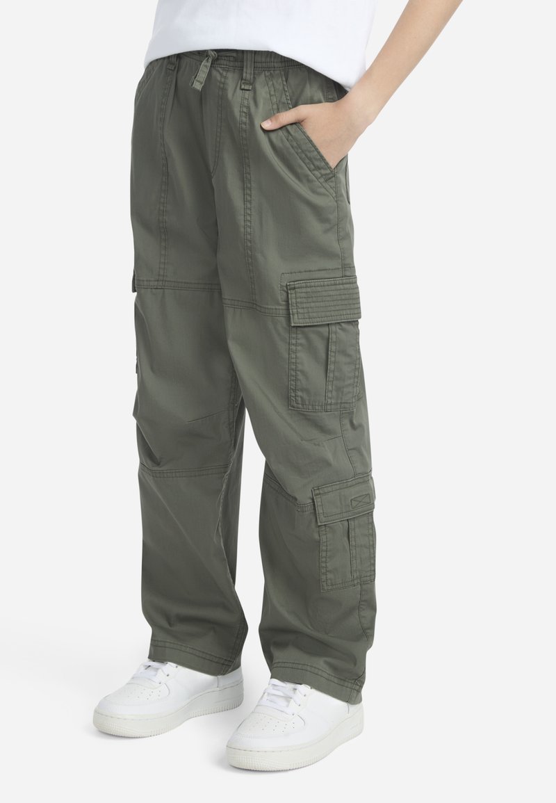 Φόρμες cargo σε ελιά πράσινο με πολλαπλές τσέπες, ρυθμιζόμενη μέση με κορδόνι και άνετη εφαρμογή. Κατασκευασμένες από ελαφρύ ύφασμα με λεία υφή.