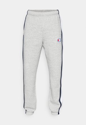 Pantalones de chándal grises con una cinturilla elástica, que cuentan con franjas laterales en color marino y un pequeño logotipo en el muslo izquierdo. Textura suave, parecida al forro.