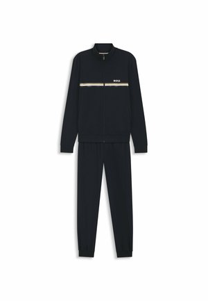 Survêtement noir pour homme avec veste zippée ornée de bandes horizontales dorées et blanches et logo "BOSS", assorti à un pantalon fuselé.