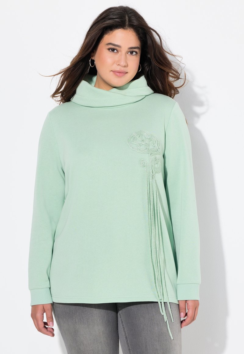 Felpa verde chiaro con collo a cappuccio, caratterizzata da un ricamo floreale e strisce pendenti sulla parte anteriore. Maniche lunghe e texture morbida.