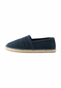 Zapato deslizante tejido en azul marino con un upper texturizado y una suela de yute natural con una costura decorativa alrededor del borde.
