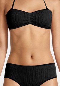 Zwarte bikiniset met een gestructureerd, geribbeld ontwerp. De top heeft een bandeaumodel met dunne bandjes en de broek heeft een hoge taille.