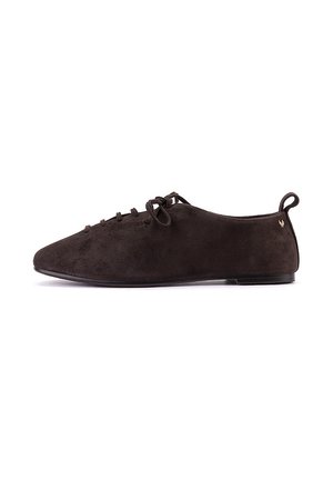 Zapato plano de ante marrón oscuro con cordones delanteros y asa en el talón, diseño minimalista y suela delgada, mostrado en perfil lateral.